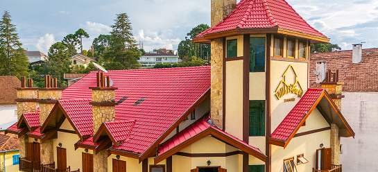 Fachada da Pousada D'Biagy Raízes destacando o elevador panorâmico e a arquitetura charmosa em Campos do Jordão