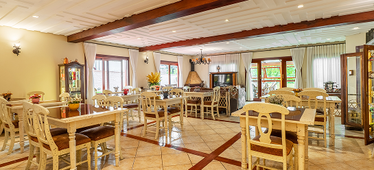 Ambiente do salão de eventos e restaurante da Pousada D'Biagy Raízes em Campos do Jordão, mobiliário em madeira