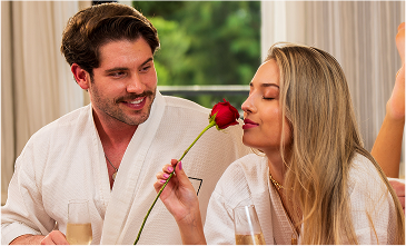 Casal em roupões na Pousada D'Biagy, desfrutando de um momento romântico, perfeito para lua de mel ou escapadas a dois.