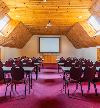 Espaço para eventos corporativos e sociais na Pousada D'Biagy Premium em Campos do Jordão, com sala de reunião, projetor e área de hospedagem.