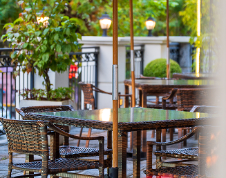 Mesas e cadeiras confortáveis em área de jardim ao ar livre da Pousada Família D'Biagy, ideal para refeições.