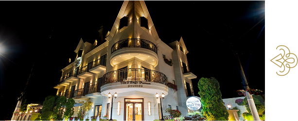 Fachada imponente e iluminada da Pousada D'Biagy Premium em Campos do Jordão à noite, destacando sua arquitetura de luxo.
